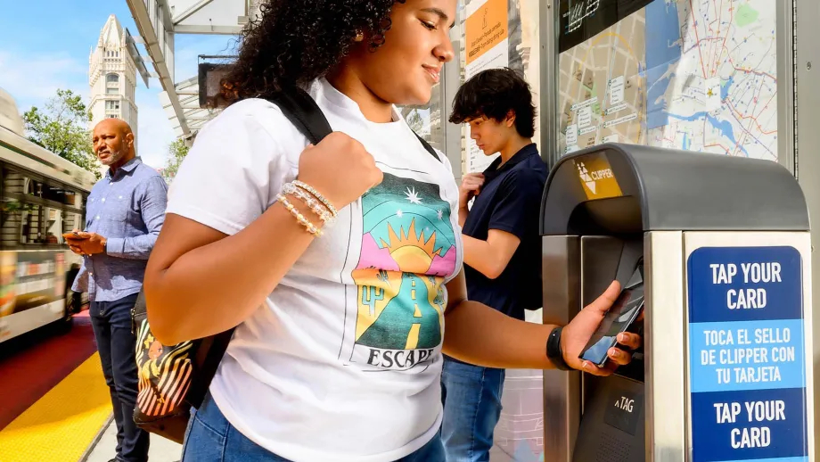 A teenager pays for transit with their phone.
