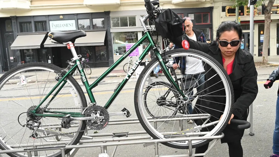 A cyclist learns how to use the front-mounted bike racks on an AC Transit bus.