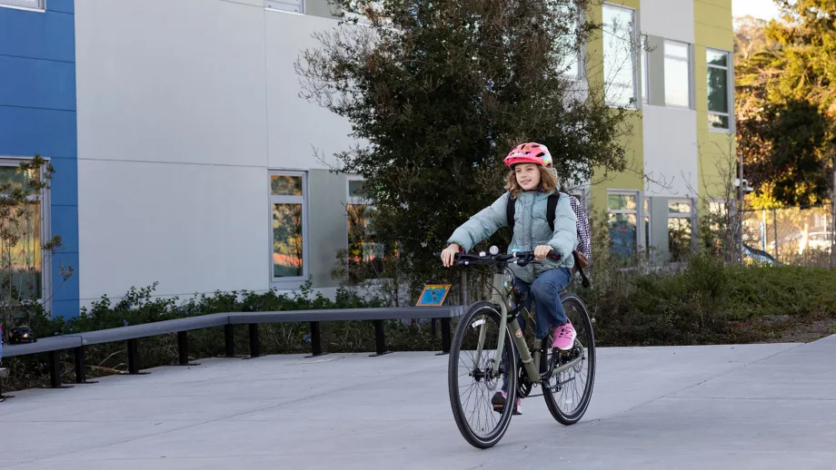 A young cyclist riding her bike to school.