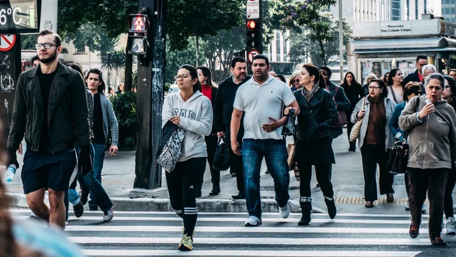 Pedestrians cross the street in the crosswalk.
